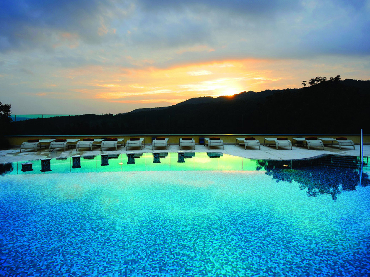 Godete la luce del tramonto dalla piscina esterna del Petriolo Spa Resort
