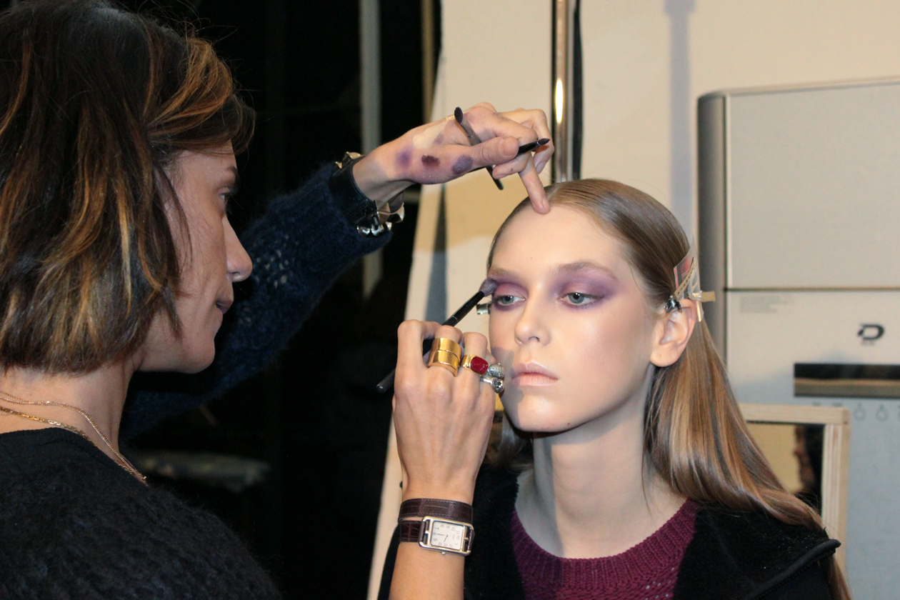 La make up artist Maud Laceppe di Mac stende una polvere viola sull’occhio della modella