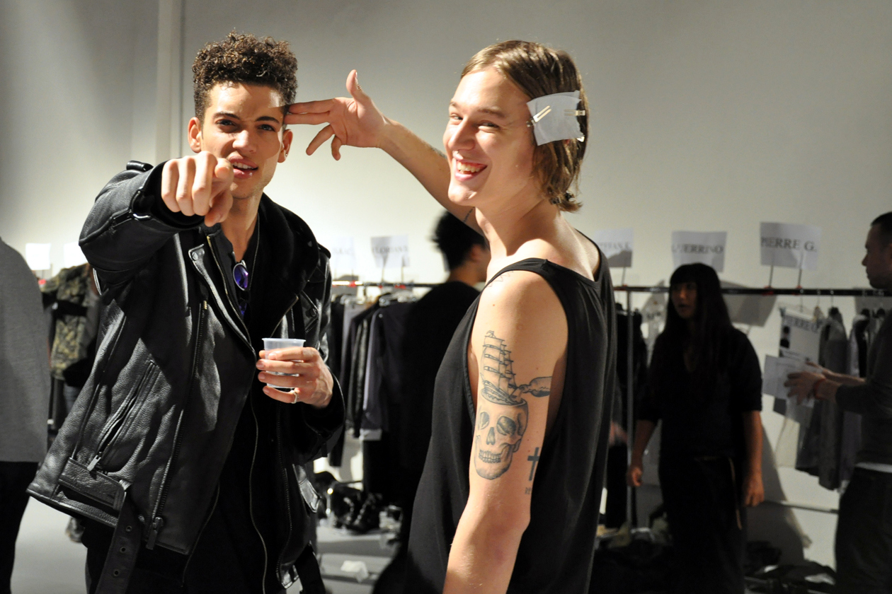 John Varvatos per l’A/I 2014-15 trasforma l’uomo in un eroe rock ispirandosi ai KISS. Il backstage beauty & hair