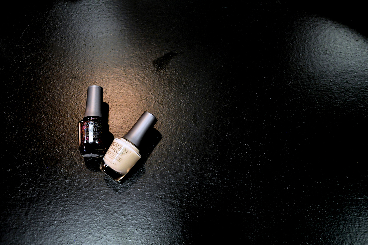 Le due nuance di smalto Morgan Taylor: State of Mind, una base nera con glitter multicolor, per le mani e In The Nude per i piedi