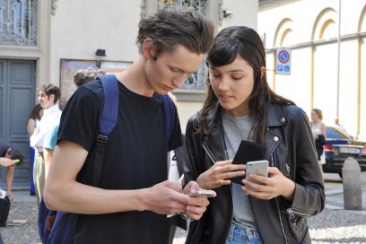 Tendenze capelli dallo street style a Milano: hair look spettinato per lui, effetto wet per lei