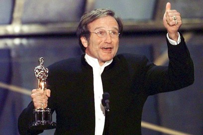 Actor Robin Williams holds up his Oscar after winn
