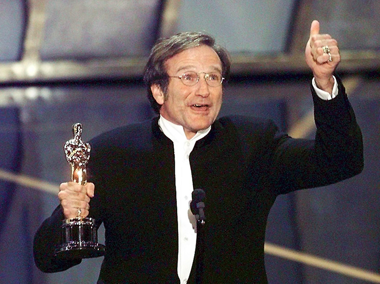 Actor Robin Williams holds up his Oscar after winn