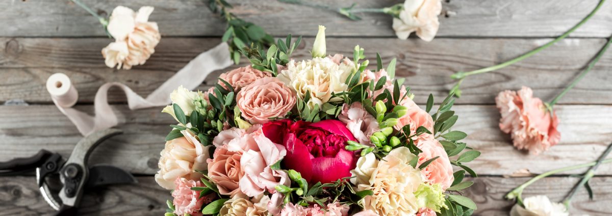 The florist desktop with working tools on gray old wooden background