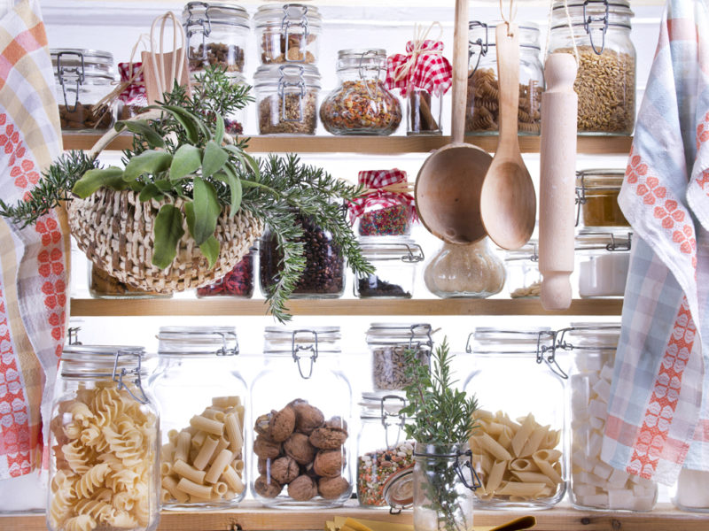 Dried foods stored in glass jars within a small pantry