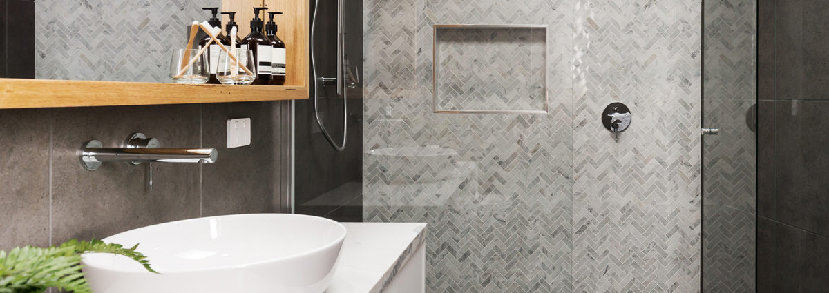 Marble mosaic herringbone tiled shower feature wall in a contemporary ensuite bathroom