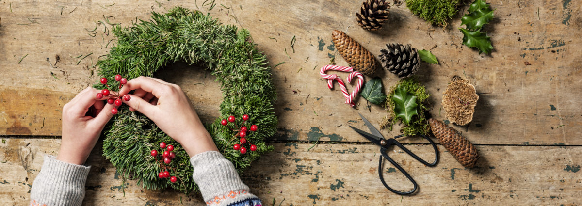 Overhead view of Christmas wreaths being made.