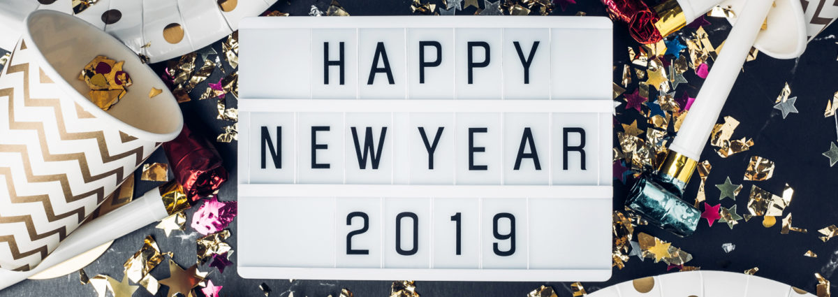 Happy new year 2019 on light box with party cup,party blower,tinsel,confetti.Fun Celebrate holiday party time table top view.
