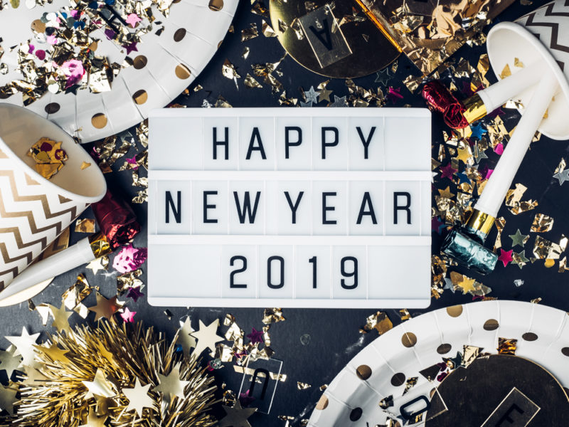 Happy new year 2019 on light box with party cup,party blower,tinsel,confetti.Fun Celebrate holiday party time table top view.