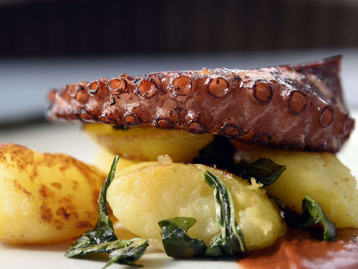 Polpo affumicato con patate croccanti al basilico e salsa di datterino alla brace