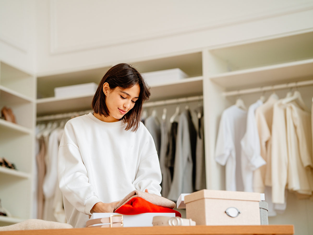 Season clothes change in a wardrobe. Calm woman change and arranging clothes for the new season