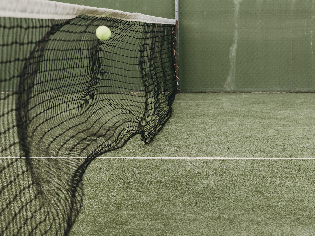 Paddle ball hitting net in court