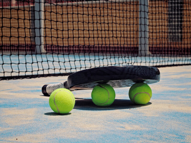 Black Padel racket with balls.