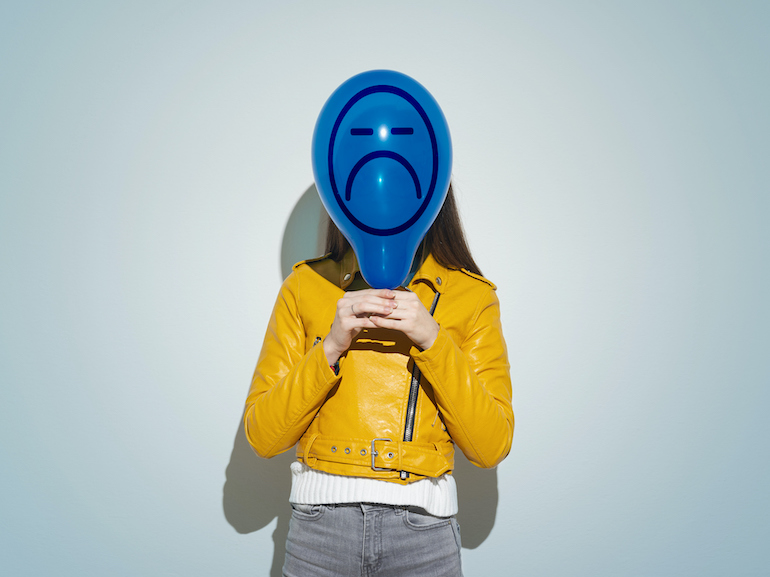 Woman Covering Face With Blue Balloon With