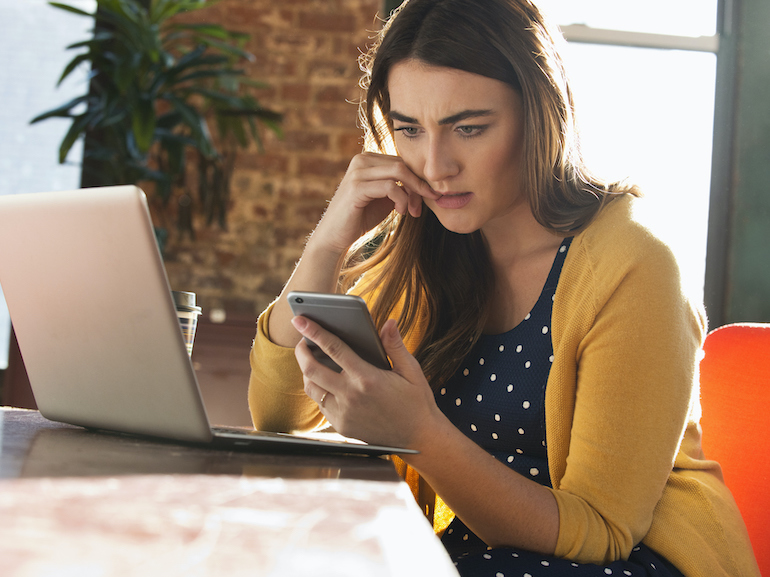 Stressed Caucasian businesswoman using cell phone