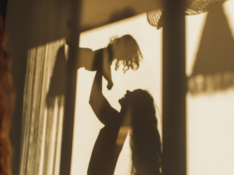 Family fun. Beautiful shadows on wall of mom playing with her daughter. Childhood concept, harmony in family