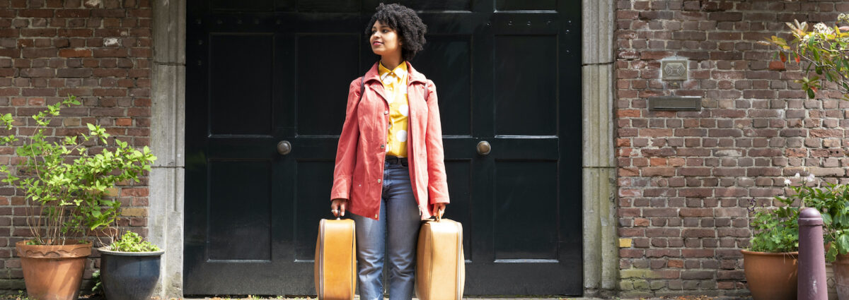 A young woman holding suitcases.