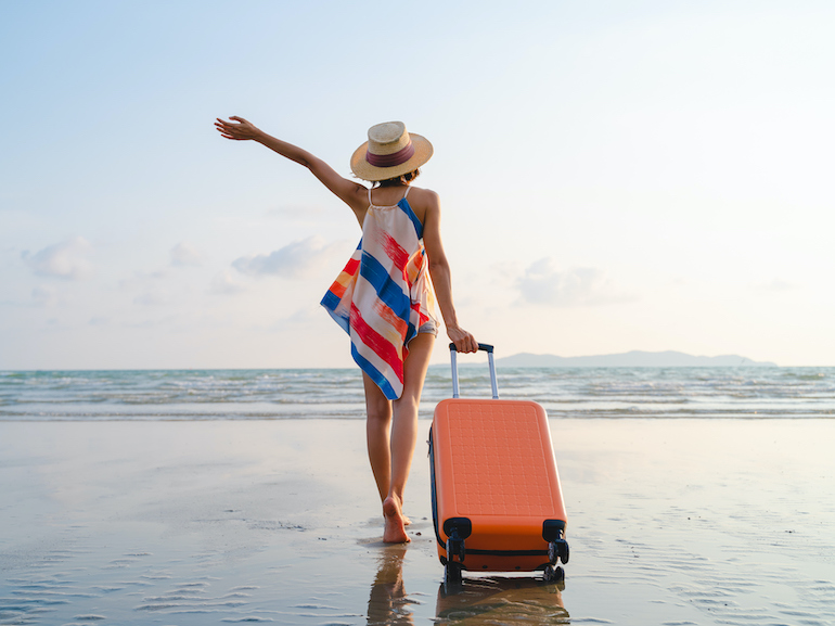 Happy Asian woman with sunhat enjoy travel on the beach in summer