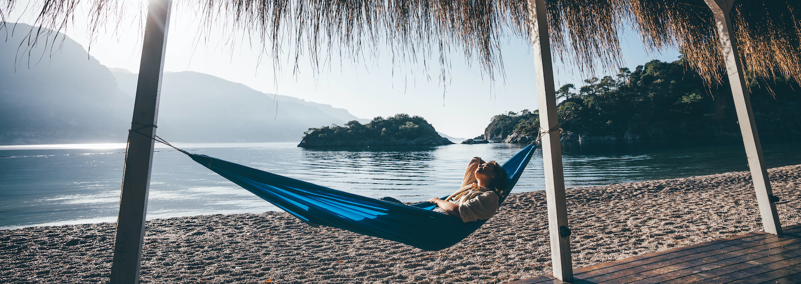 Woman relaxing in hammock on beach