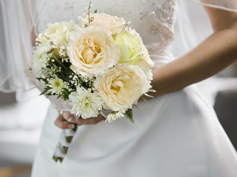 Bride holding bouquet, mid section