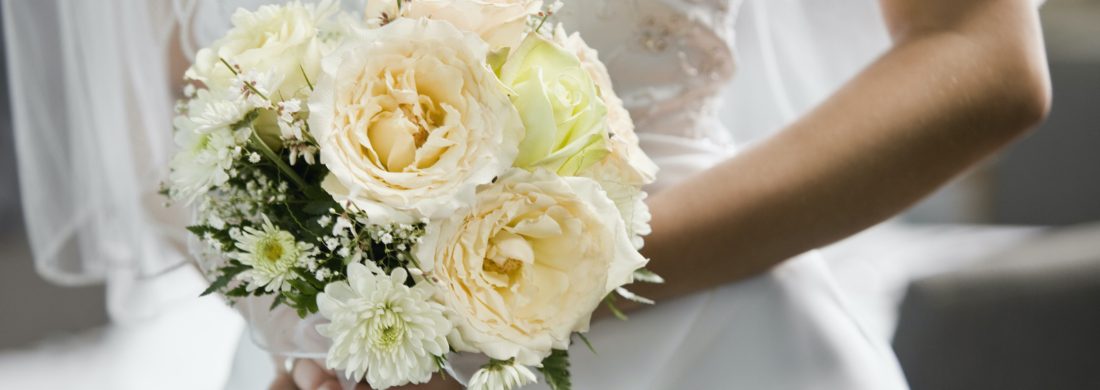 Bride holding bouquet, mid section