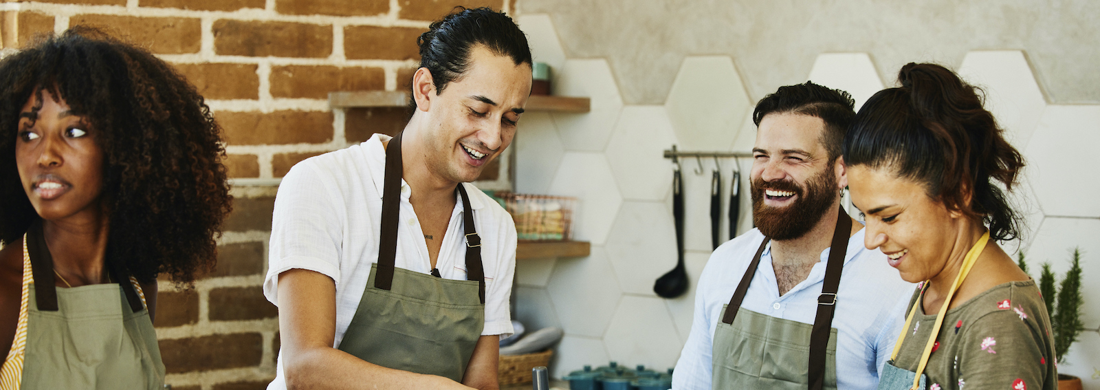 Medium shot of students laughing with female chef during cooking class