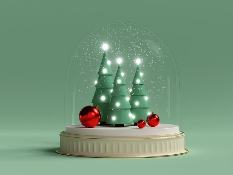 Christmas trees and balls under snow in a glass dome. Creative still life with copy space