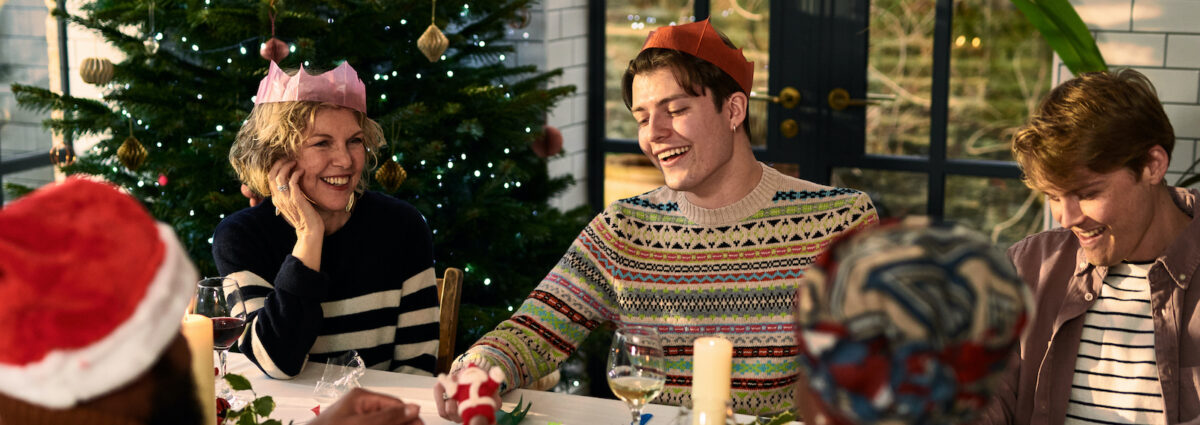 Cheerful family sitting down after Christmas dinner playing games