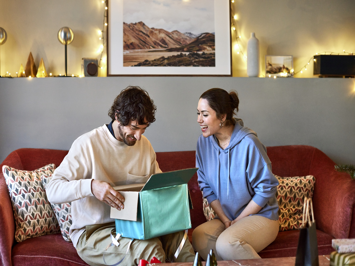 Happy couple with Christmas present at home