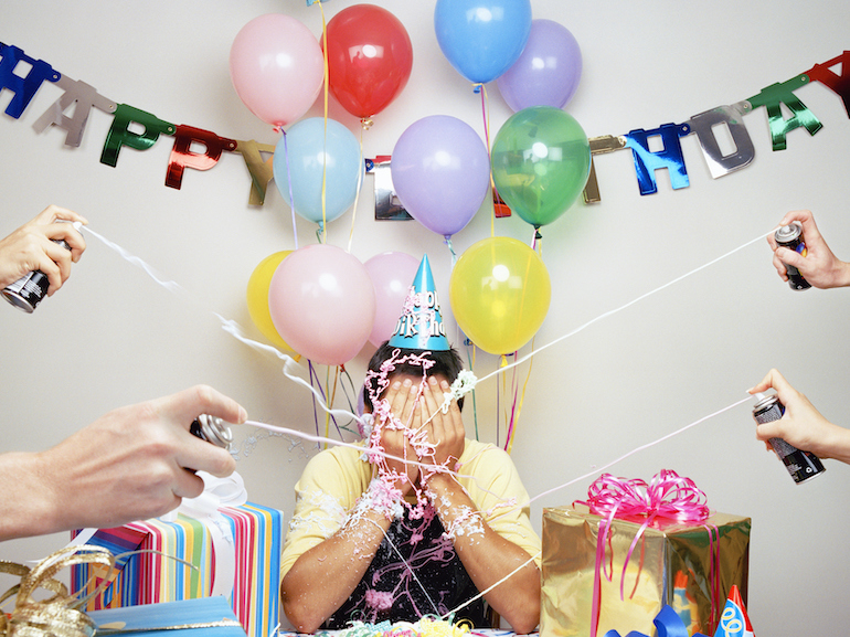 Group of people spraying man with spray string