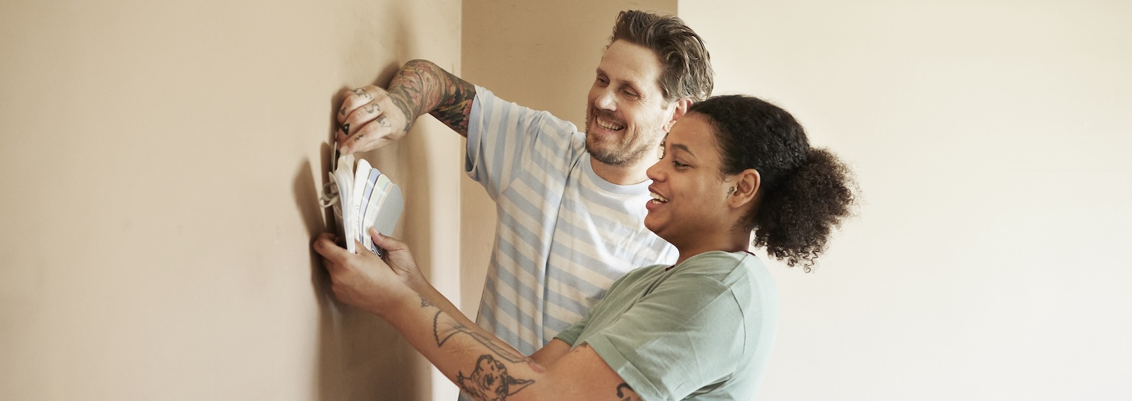 Smiling couple choosing paint color for home