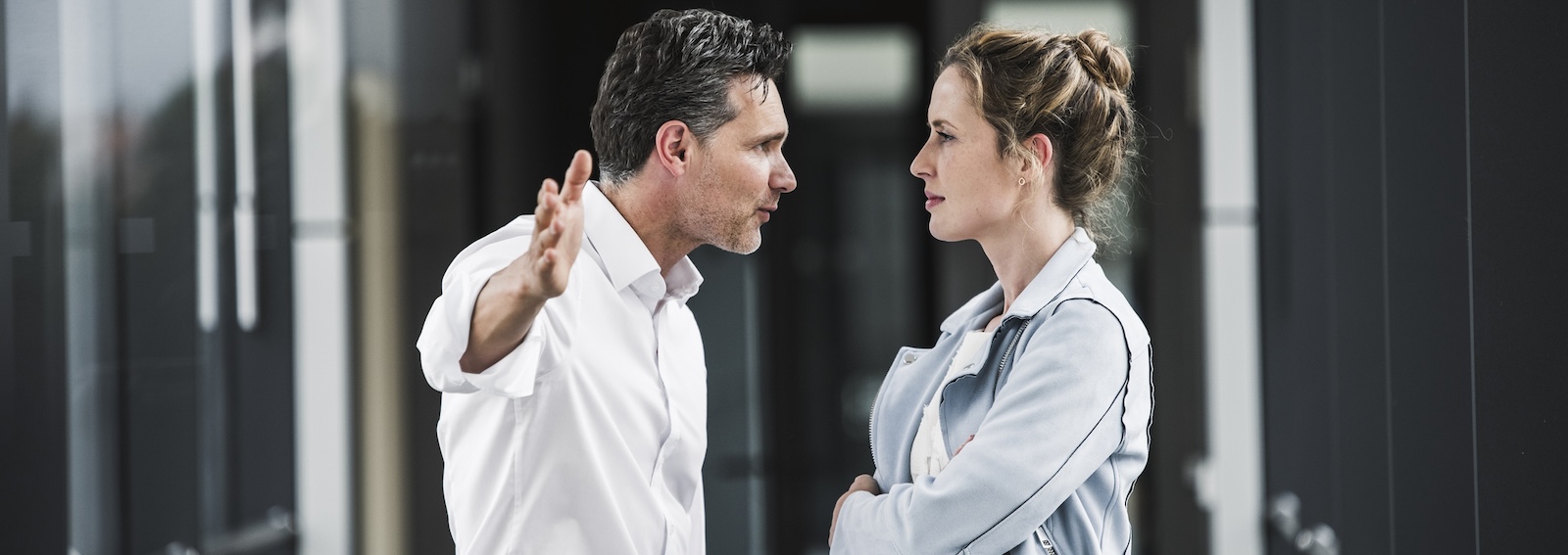 Businesswoman and businessman arguing in office passageway