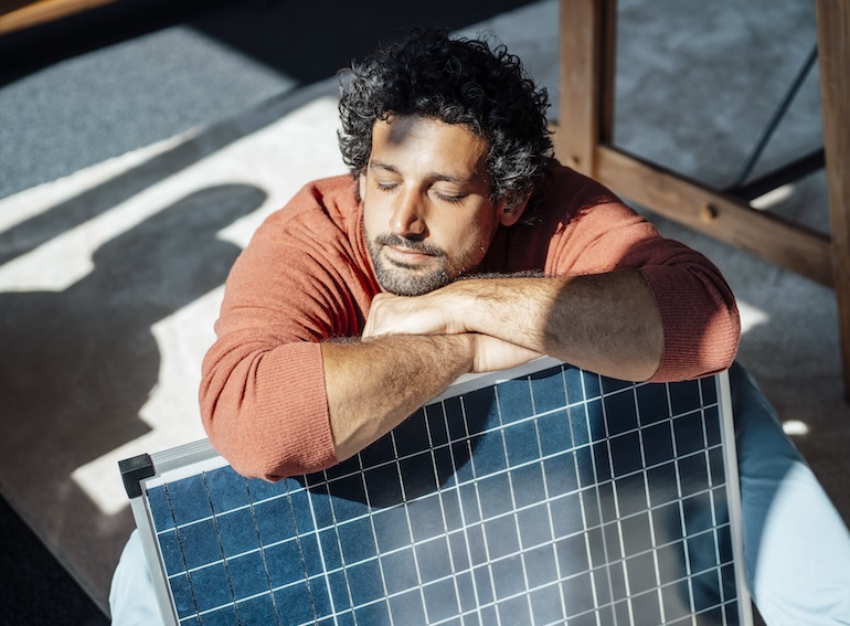 Businessman with solar panel under sunlight in office
