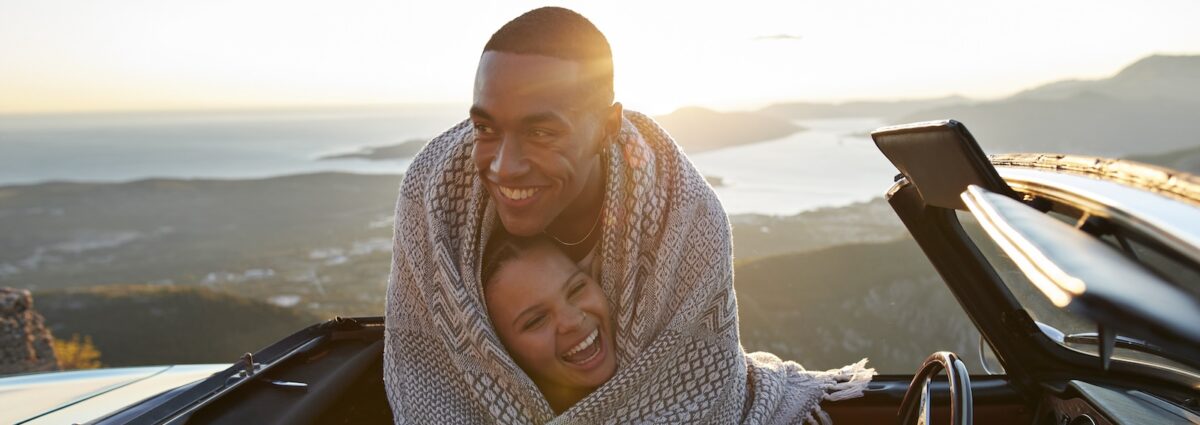 Man embracing girlfriend in convertible car