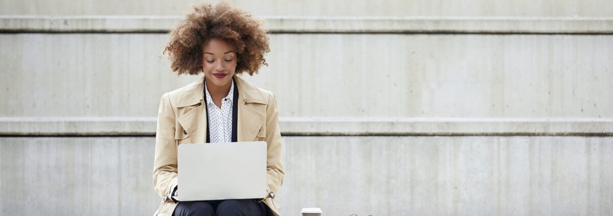 Young businesswoman using laptop on steps
