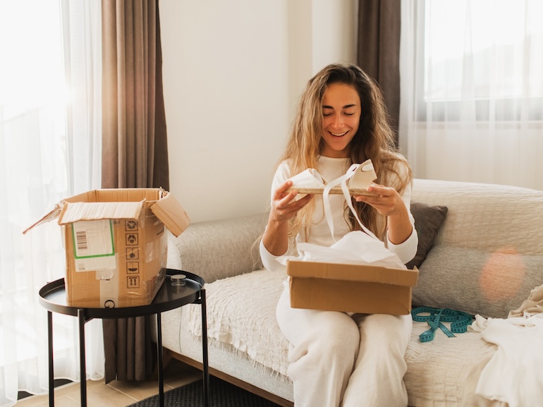 Woman looking at online purchased fashion clothing.